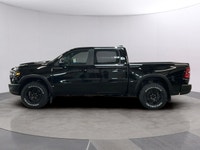 The 2026 Ram 1500 Rebel 4x4 Crew Cab in a striking black hue offers a commanding presence on any ter... (image 1)