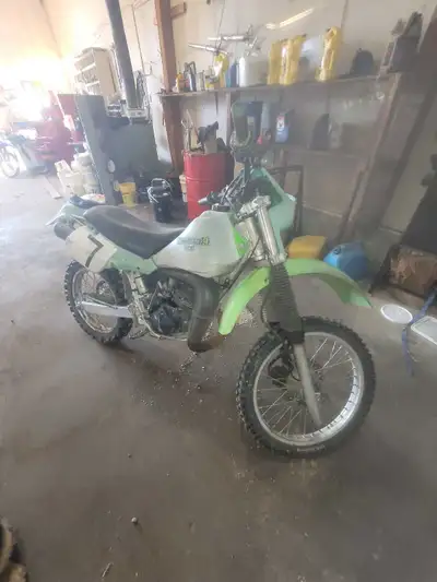 This Kawasaki 1986 KDX200 is a classic two-stroke dirt bike featuring a lightweight frame and agile...