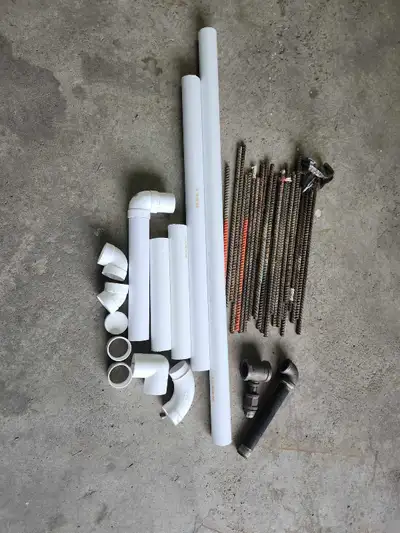 This lot includes a variety of PVC piping, assorted plumbing fittings, and steel rebar, all in used...