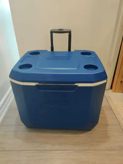 Blue Coleman rolling cooler with a retractable handle. It has four cup holders on top. Great for cam...
