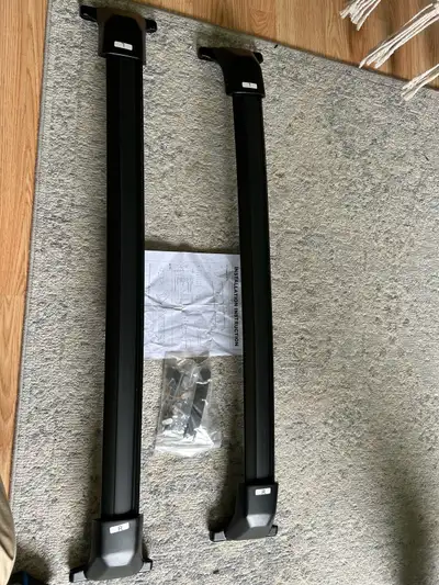 I'm selling a new set of crossbar or roof rack components, perfect for securely mounting cargo carri...