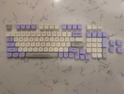 Upgrade your mechanical keyboard with this set of custom keycaps featuring a soothing lavender, whit...