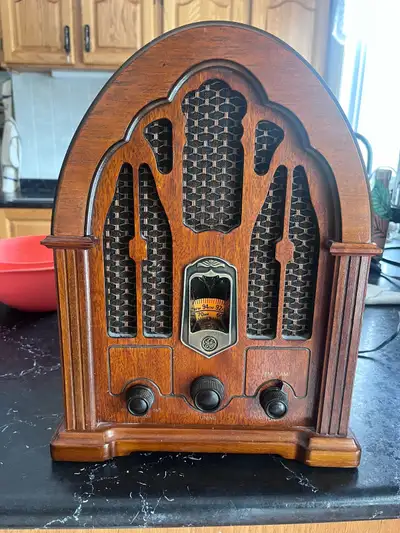This is a vintage General Electric (GE) radio that features AM/FM and has a wooden case, offering a...
