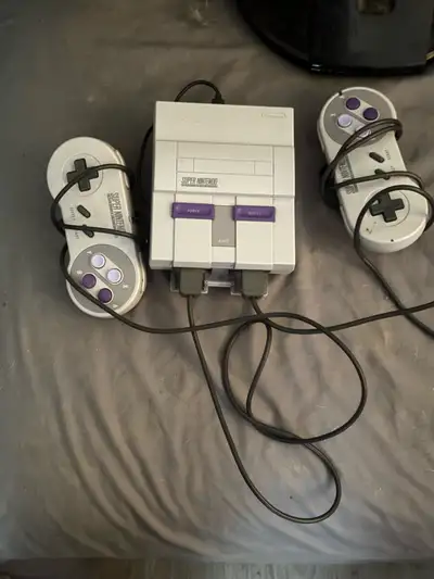Relive the 90s with this used Nintendo Super NES Classic Edition, complete with two controllers for...