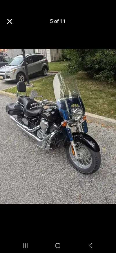 This black Kawasak 2006 cruiser motorcycle comes equipped with saddlebags for convenient storage. It...