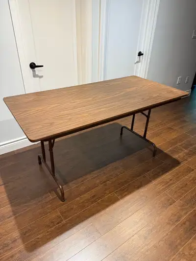This sturdy folding table features a durable wood-grain laminate top and a metal frame, making it a...