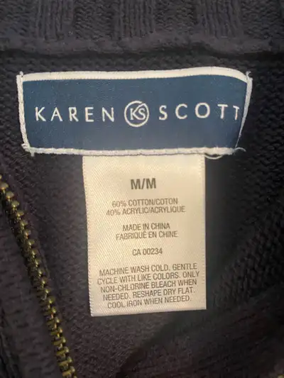 This is a used Karen Scott navy blue zip-up sweater in medium. It's a cozy and stylish piece, perfec...