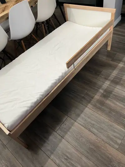 IKEA Sniglar bed and IKEA Underlig mattress. Wooden toddler bed frame with a white headboard. Includ...