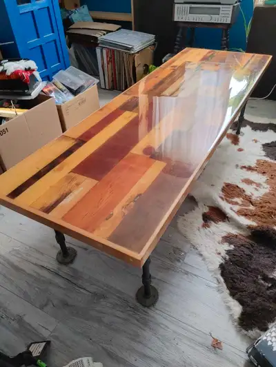 Long Epoxy Wooden Table with lead pipe style legs. Clear glossy finish with little wear and tear. Ve...