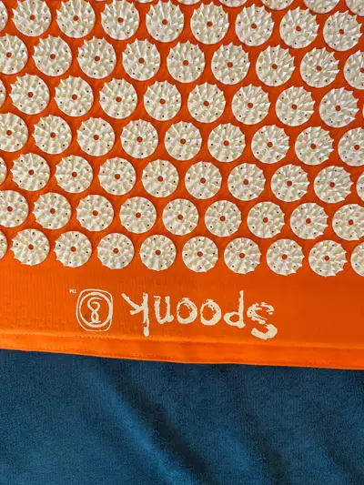 Découvrez le tapis d'acupression Spoonk, votre allié bien-être! Ce tapis d'acupression orange vif es...