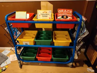 Rolling metal cart for storing books or toys. Very sturdy and in excellent condition. Comes with 9 b...