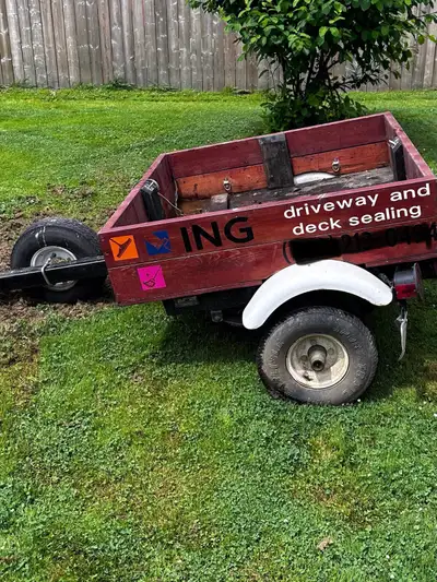 This sturdy pre-owned utility trailer features a durable wooden box design, ideal for hauling landsc...