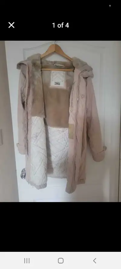This is a used TNA parka in a size XS with a cozy faux fur lining and a stylish, long silhouette, pe...