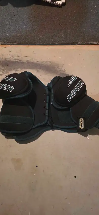 These Bauer SP300 hockey shoulder pads are pre-owned and offer solid protection for your next game o...