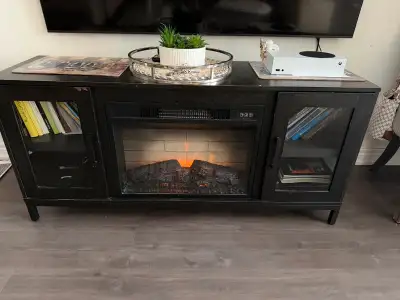 This black TV stand features a built-in electric fireplace for a cozy ambiance. It offers ample stor...