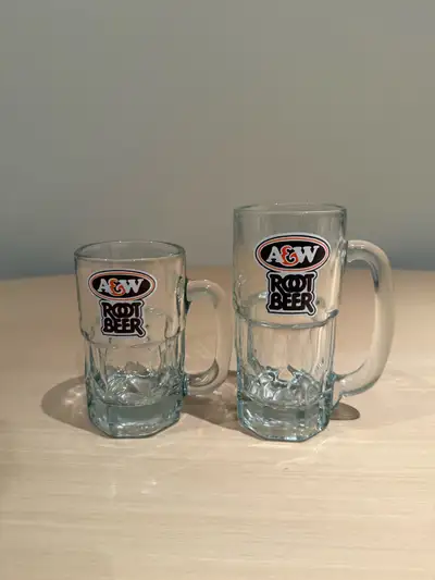 These are two classic A&W Root Beer glass mugs, one slightly larger than the other, perfect for enjo...
