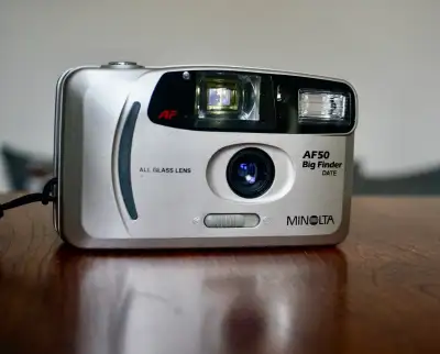 Autofocus 35mm point-and-shoot camera released by Minolta in 1997. * Lens: Minolta 27mm f5.6 All Gla...