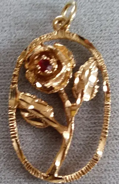 Pendentif représentant une rose Or jaune10K Pierre précieuse: grenat (le cœur de la rose) Dimension:...