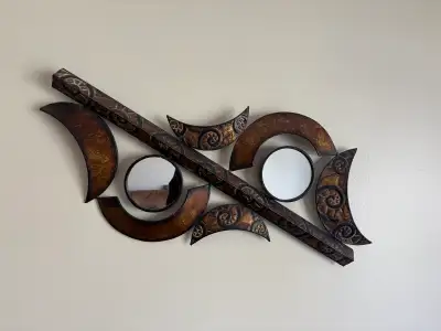 Add a touch of unique artistry to your living space with this eye-catching metal wall decor featurin...