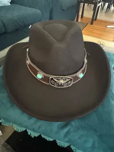 ack cowboy hat with a decorative leather band featuring turquoise-coloured accents. It's made with 3...