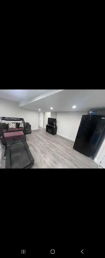 This spacious and bright walkout basement apartment features a clean, modern aesthetic with wood-loo...
