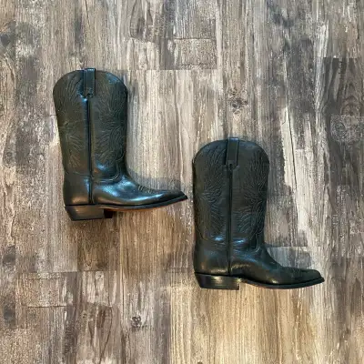 These are a pair of used Tom Houston black leather cowboy boots, perfect for adding a touch of Weste...