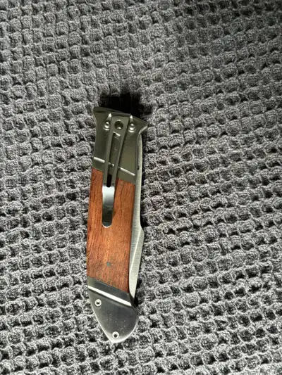This is a new SOG folding knife with a wood handle and a sharp blade, perfect for everyday carry. It...