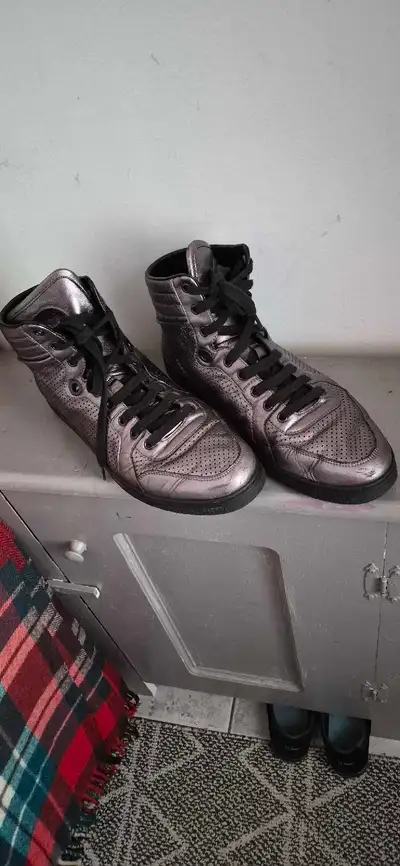 These Gucci metallic grey high-top sneakers are in good pre-owned condition and feature a sleek, per...
