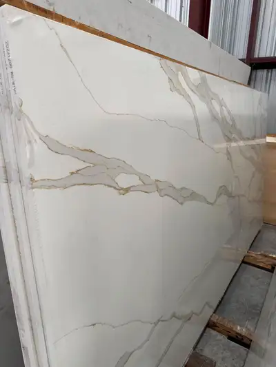 This brand new Calcatta Gold quartz slab features a stunning white base with elegant, flowing gold v...