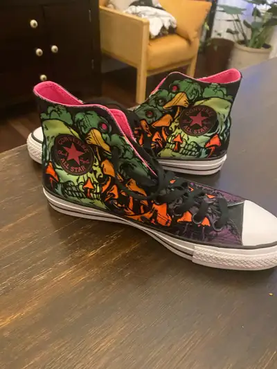 These Converse Chuck Taylor All Star high top sneakers feature a vibrant, neon-coloured skull print...
