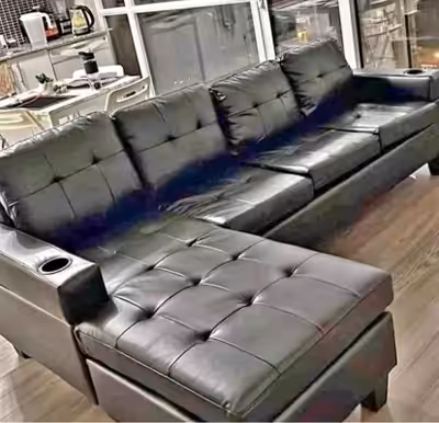 This is a used black faux leather sectional sofa, perfect for a living room or entertainment space,...