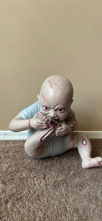 This eerie zombie baby prop is a perfect, spine-chilling addition to your Halloween decorations, fea...