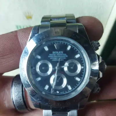 This pre-owned Rolex Daytona, featuring a striking black dial and iconic chronograph functionality,...