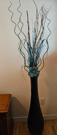 Grand vase brun avec branches et fleur.