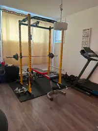 Squat rack with barbell, lat pulldown attachment and weight plat