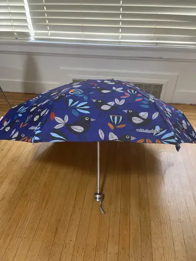 Selling two foldable umbrella with a vibrant bird and leaf print and printed strips great for rainy...