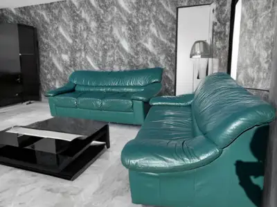 This used leather sofa and loveseat set features a durable green finish, perfect for adding a pop of...