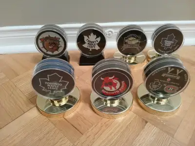 7 assorted hockey pucks in holders - like new, View more