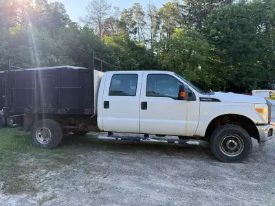 This Ford F-350 is a hardworking crew cab pickup truck equipped with a stake side body. Please note...