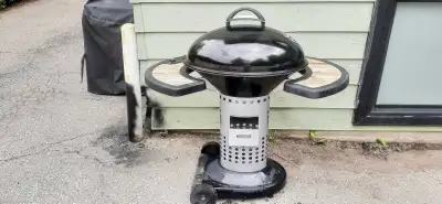 Selling a Coleman portable propane smoker grill. It has a black lid and a silver body with two wheel...