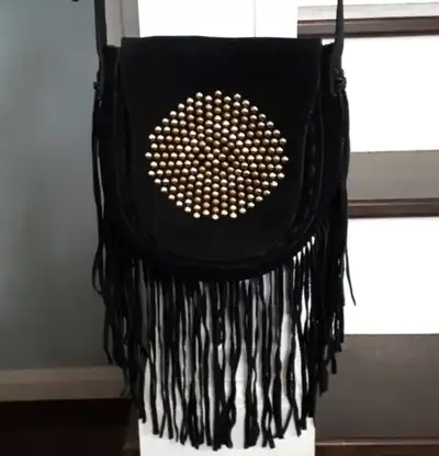 This boho/rocker chic black suede bag from Steve Madden has a half oval shape with a fold over flap...