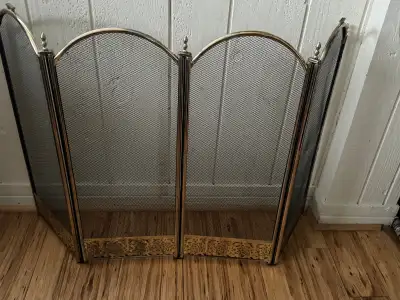 4 Panel Fireplace Screen with brass accents on the bottom . Four metal framed and mesh panels in a a...