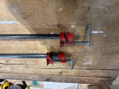 These are two used pipe clamps, ideal for any woodworking or metalworking project requiring a strong...