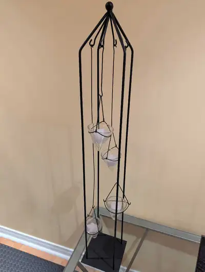 Selling a tall metal hanging candle holder stand. Holds four glass candle cups that hang at differen...
