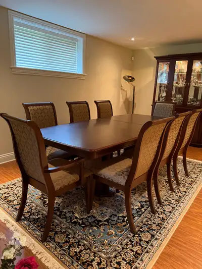 Dark wood extendable dining table with 8 matching chairs; table can be adjusted to seat 6 or extende...
