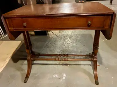 This is a used, antique hall table that has a drop leaf on either side of a drawer. It's in good con...
