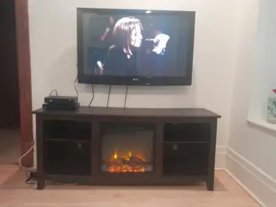 Très beau meuble TV brun foncé avec foyer électrique intégré, en excellent état. ✔ Compatible avec l...