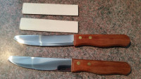 Deux couteaux à steak de cuisine avec manche large en bois.