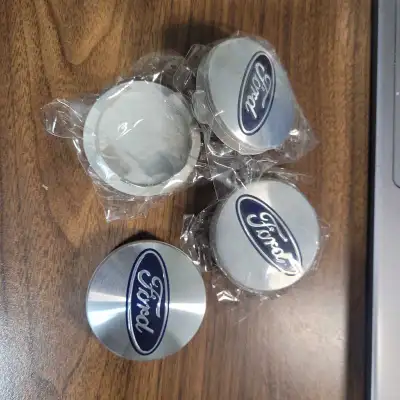 These are a new set of Ford hub caps with the Ford logo in silver and blue, crafted in Germany. Thes...