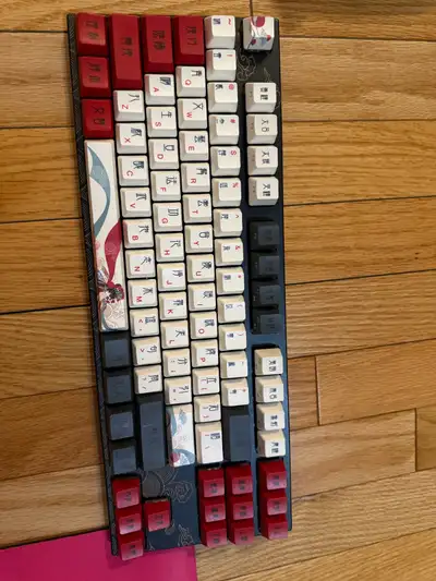This is a used custom mechanical keyboard featuring unique, artistic keycaps and a compact layout, p...